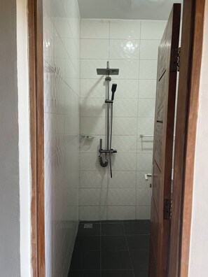 Deluxe tweepersoonskamer, uitzicht op oceaan, langs het strand | Badkamer | Een douche, handdoeken, zeep, toiletpapier