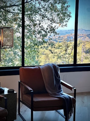 A room with a large window offering a view of a mountainous landscape. - EPIC VIEWS / SAUNA / GYM / SPEAKEASY / COLD PLUNGE / LUX / BOTIQUE CHALET (Lake Arrowhead)
