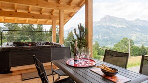 A wooden deck with a table set for a meal, overlooking a mountainous landscape. - Chalet Eteila Combloux proche Megève (Combloux)