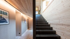 A modern interior with a wooden staircase leading to a higher floor. - Chalet Eteila Combloux proche Megève (Combloux)