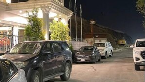 A multi-story hotel with a classic architectural design, featuring a prominent entrance with a canopy and a parking area with several cars. - Zekra Alkawther Hotel (Taif)