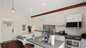 A modern kitchen with a central island, stainless steel appliances, and a bar stool.