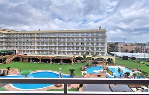 A hotel with multiple balconies, a swimming pool, and a landscaped garden. - Apartment Columbo Go2lloret (Lloret de Mar)