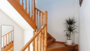 Eine Holztreppe mit einer weißen Wand und einem Blumentopf auf der Setzebene.