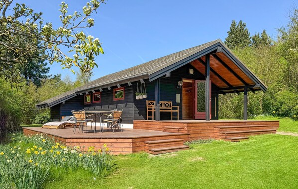 A cabin with a deck, outdoor seating, and a covered porch. - 2 bedroom amazing home in Præstø (Præstø)