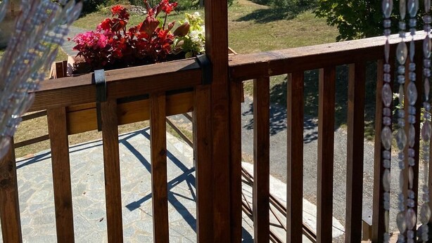 Una terraza de madera con vistas a un paisaje montañoso.