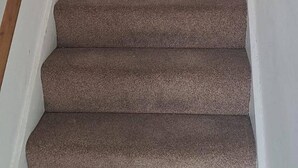 Una scala tappezzata con corrimani in legno che conduce a un piano superiore.