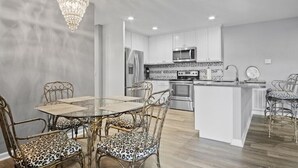 A modern kitchen with white cabinets, stainless steel appliances, and a central island.