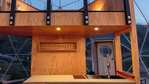A modern, multi-level wooden structure with a bar area and seating. - Escarpment Domes (Porirua)