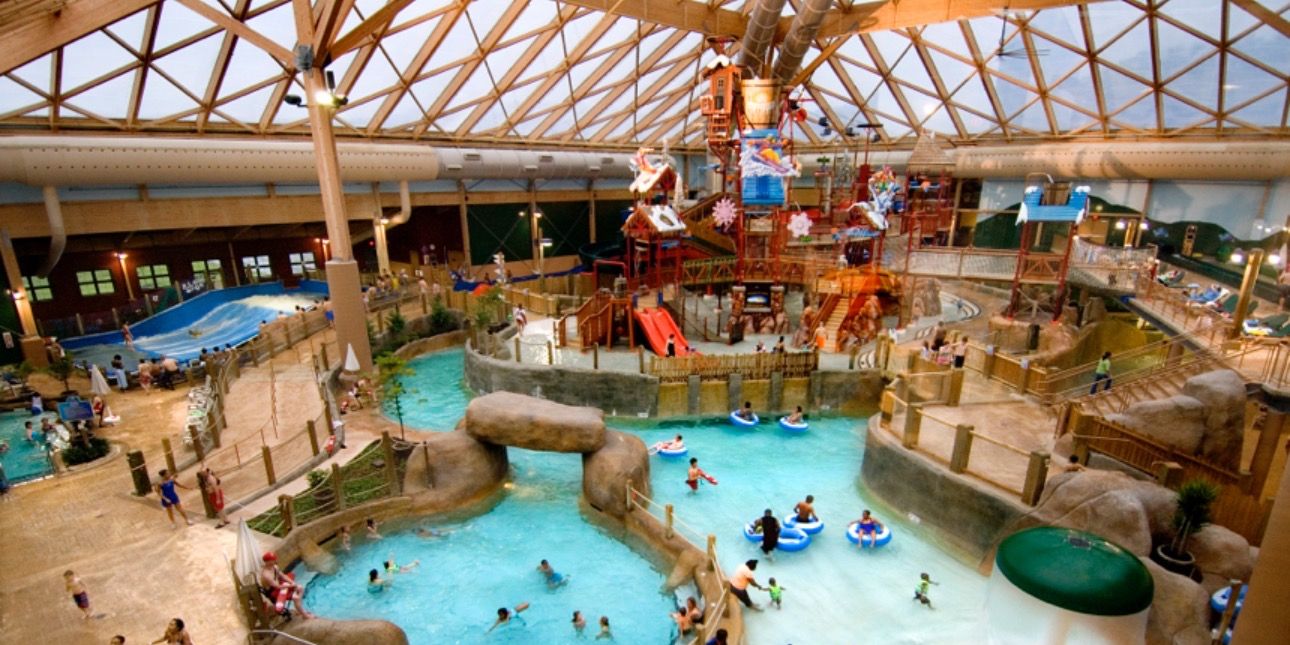 Ein großer Indoor-Wasserpark mit mehreren Pools, Rutschen und Spielbereichen.