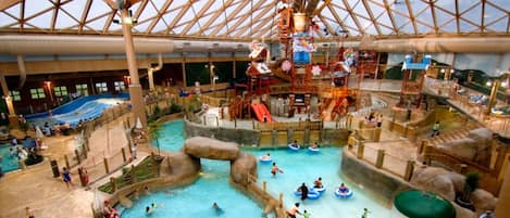 An indoor water park with multiple pools, slides, and play structures.