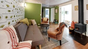Un salon comprenant un canapé, des fauteuils, une table ronde et une cheminée.