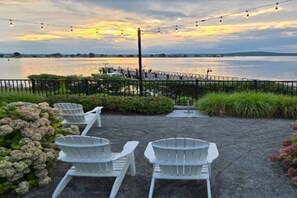 A waterfront patio with outdoor seating and a view of the water.