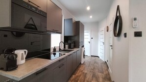 A modern kitchen with a built-in oven, a coffee machine, and a sink. - 2 bedroom gorgeous home in Hellendoorn (Hellendoorn)