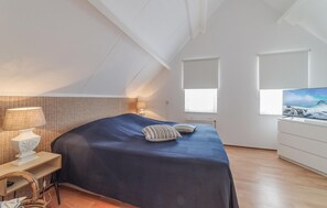 Relax in this stylish bedroom with a large bed, bedside table, and flat-screen TV.