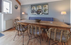 Cozy dining area with a long table and four chairs, tufted bench, and a window with a bird's view.