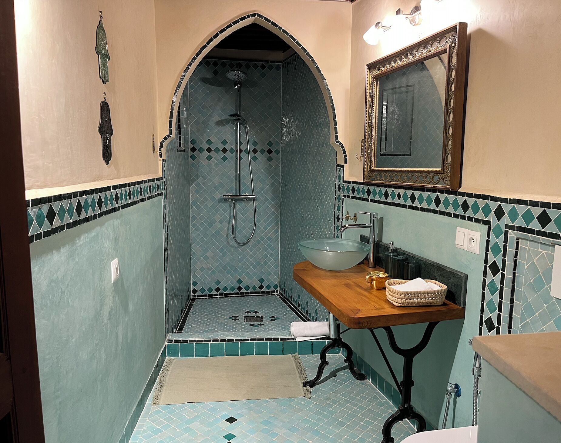 A bathroom with a shower, sink, and mirror.