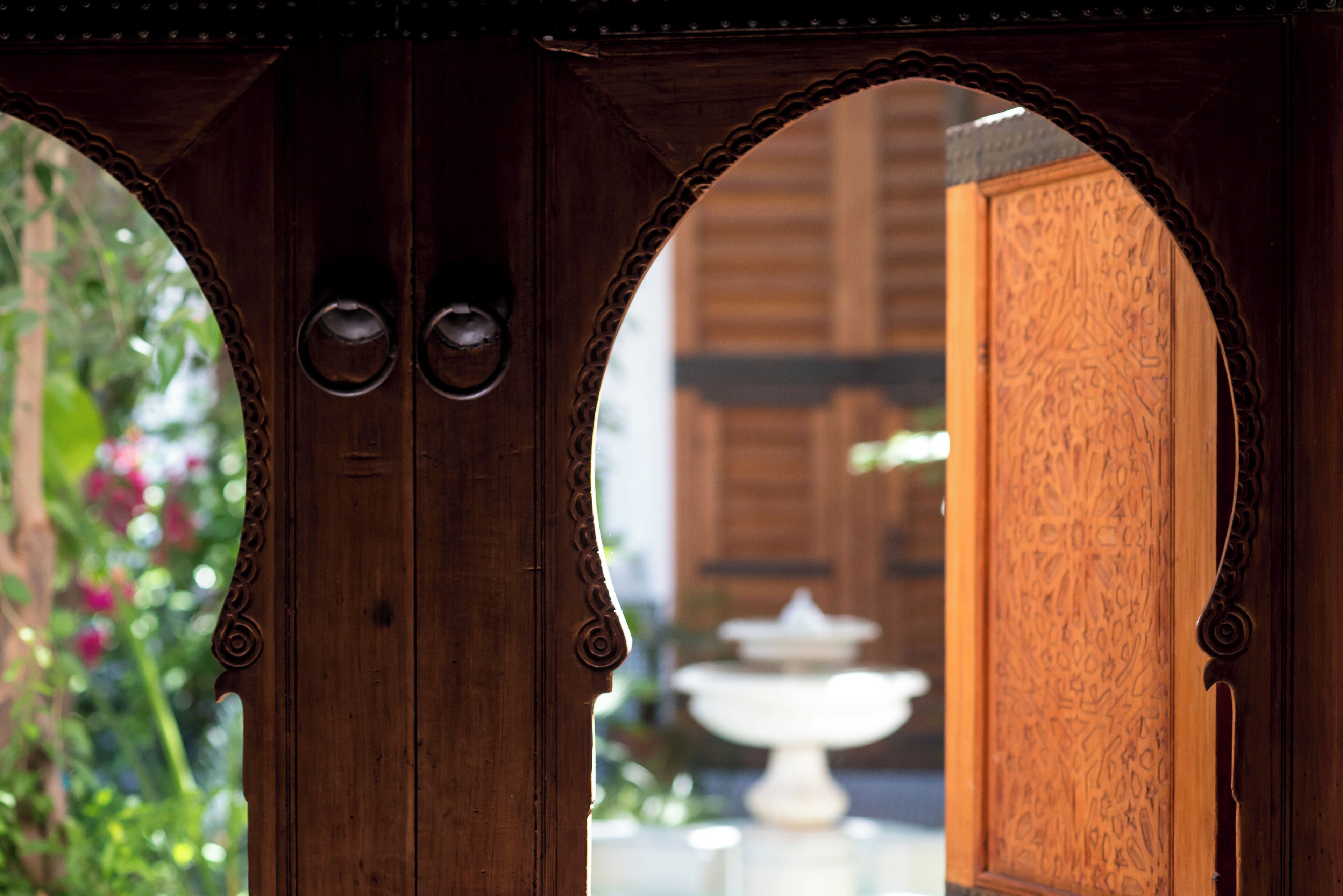 Una puerta de madera con tallas elaboradas y un ventanal circular.
