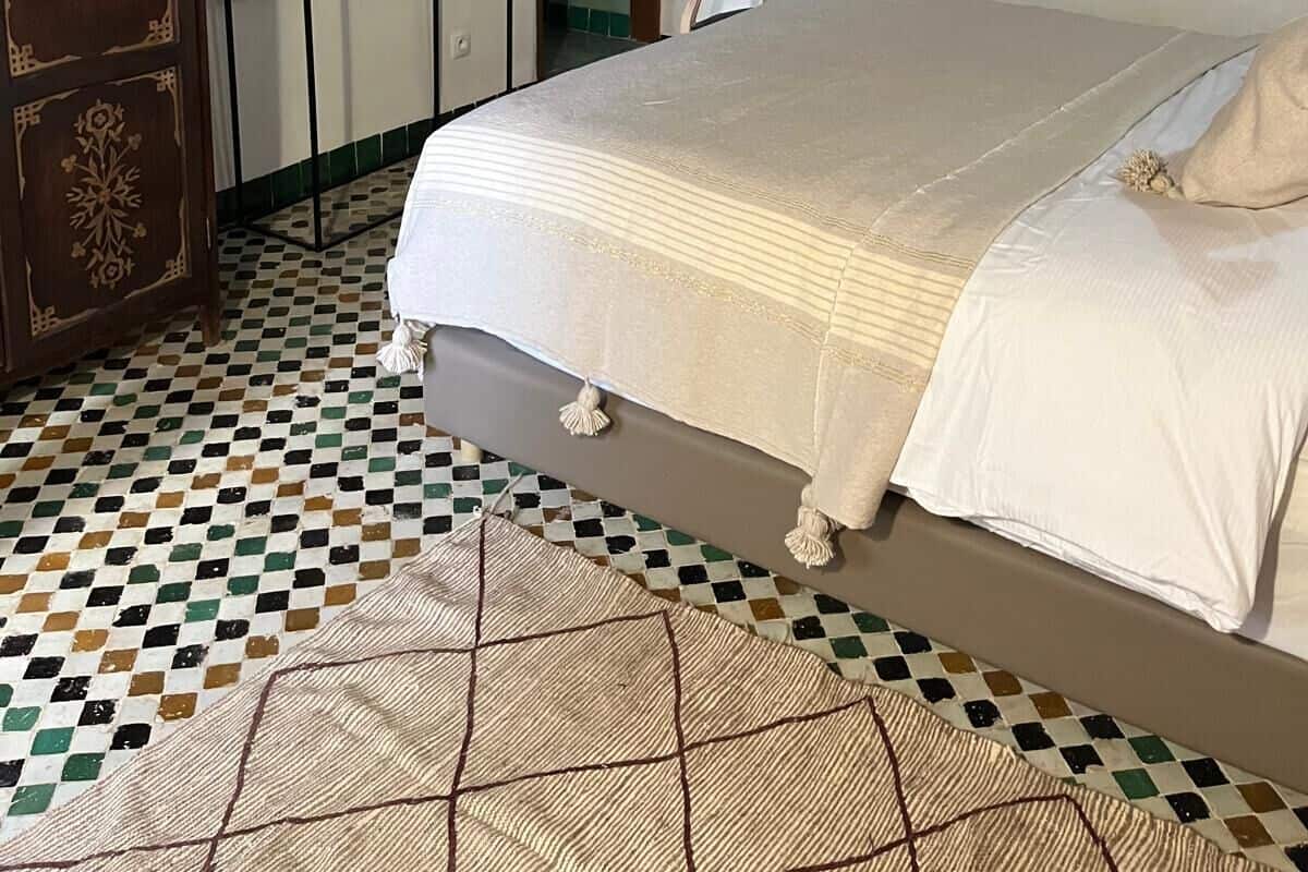 A bedroom with a bed, a dresser, a mirror, and a door.