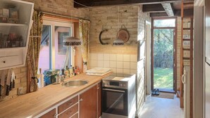 Una cocina con encimera de madera, horno empotrado y un lavamanos.