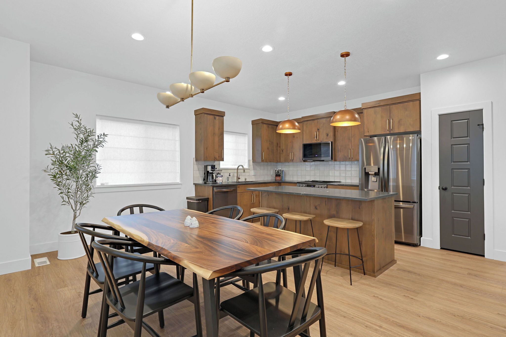 Una cocina moderna con armarios de madera, electrodomésticos de acero inoxidable y una isla central.
