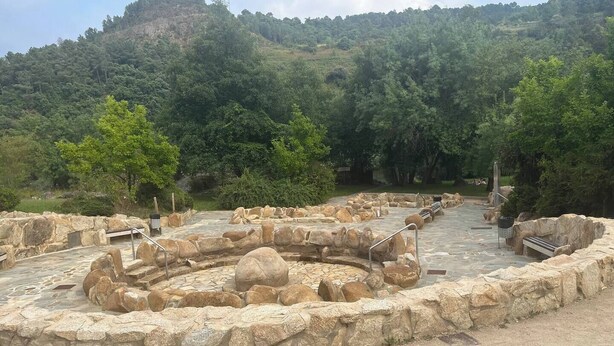 Un sitio arqueológico con estructuras de piedra y senderos.