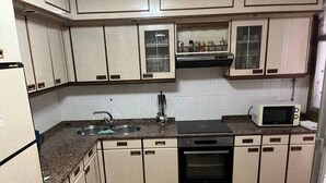 Una cocina equipada con pileta, estufa, horno, microondas y alacenas.