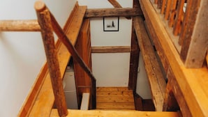 Una escalera de madera con barandilla de madera y un pequeño cuadro enmarcado en la pared.