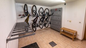 A bike storage area with multiple bicycles, a wooden bench, and a metal rack.