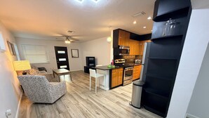 A modern kitchen with wooden cabinets, a stainless steel oven, and a black refrigerator. - Charming 3‑BR Sarasota Retreat — Minutes to Beaches & Downtown (Sarasota)
