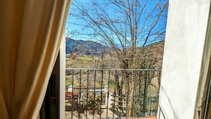 Un balcon avec vue sur les montagnes et un arbre.