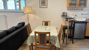 A compact living space with a dining area, kitchenette, and a sofa. - Spacious and quiet  1-bedroom  place in Munich. Fully equipped sleeps 7 guests! (Munich)
