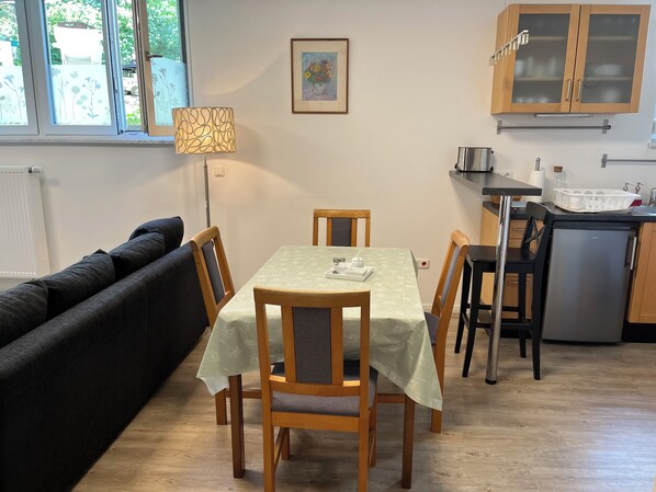 Un espace de vie compact comprenant un coin repas, une kitchenette et un canapé.