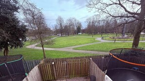 Une terrasse en bois avec un trampoline, une table et des chaises.