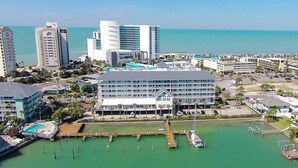 A coastal hotel with a marina, multiple buildings, and a clear view of the ocean.