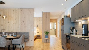 A modern kitchen with wooden flooring, grey cabinets, and stainless steel appliances. - Mountain Suite Nr 301 by Interhome (Grossarl)