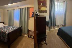 Une chambre avec deux lits, un bureau et une chaise.