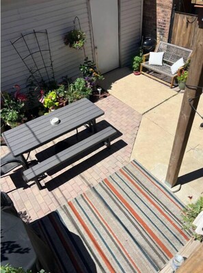 Une terrasse avec une table de pique-nique et un tapis à rayures.