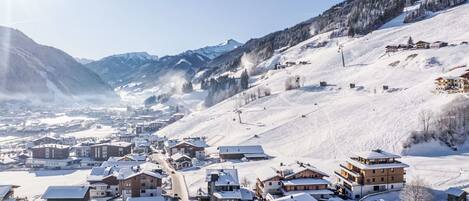 Un village enneigé avec des bâtiments et une piste de ski.