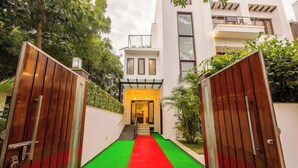 Un edificio moderno con una alfombra roja que conduce a una entrada amarilla.
