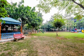 Relax in a serene park setting surrounded by lush greenery and a playground for the whole family.