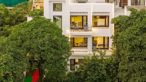 A modern multi-story building with balconies and large windows. - Nature-inspired luxury 1 BHK (Gurugram)