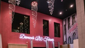 A modern interior with a neon sign reading "Diamonds are Forever" and a view of an adjacent building with the sign "NASHVILLE". - Diamonds Are Forever, Ultimate Bachelorette Pad! Walk to Broadway! Pool. Gym, Parking & More (Nashville)