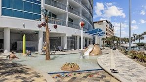 Ein Wasserparkbereich mit Pool, Rutschen und einer Dekoration aus einem Strandball.