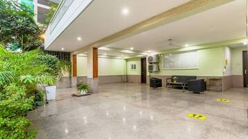 A spacious indoor area with a polished floor, seating arrangements, and a reception desk.