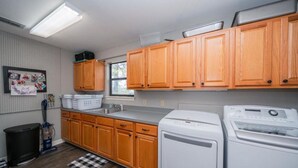 Una cocina compacta con armarios de madera, lavadora y refrigerador.