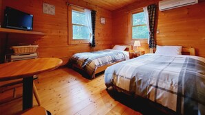 A cabin room with two beds, a television, a table, and a window with curtains. - Pension J-HOUSE (Kiso)