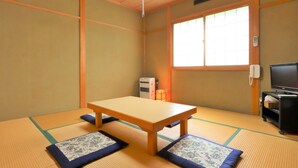 A traditional Japanese room with tatami flooring, a low wooden table, a television, and a window with a view. - Pension J-HOUSE (Kiso)