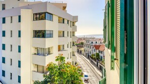 A modern multi-story building with balconies, a street view, and a clear sky. - Funchal Panoramic View, a Home in Madeira (Funchal)
