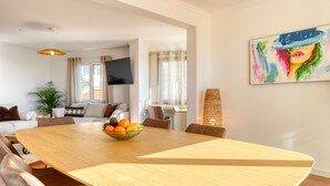 A spacious dining area with a wooden table, leather chairs, and a bowl of fruit. - Funchal Panoramic View, a Home in Madeira (Funchal)